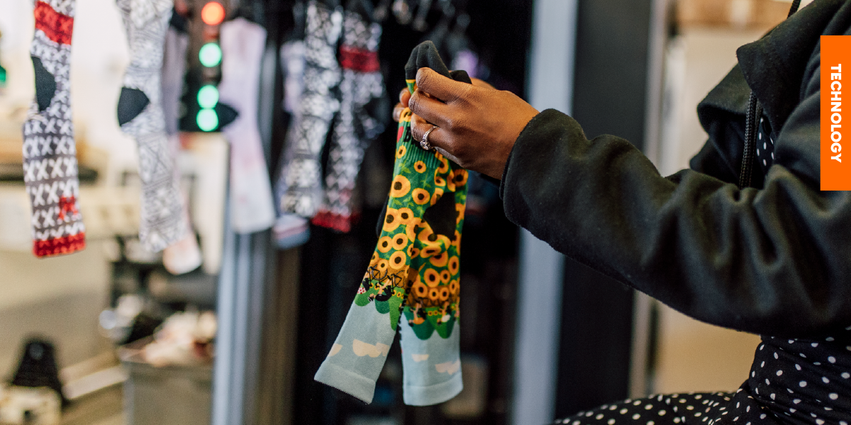 An operator in the sock finishing department inspecting a pair of freshly printed custom socks, ensuring high-quality manufacturing standards.